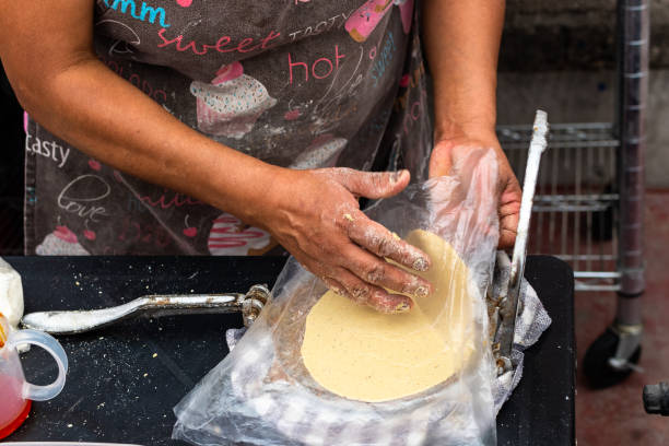 istock woman's hand preparing dough to do tortillas in a special machine 1326715425