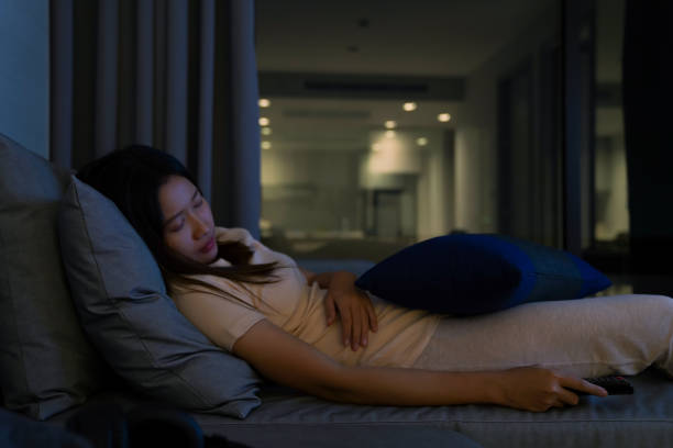 istock Asian woman sleeping on sofa while watching television at night 1326731744