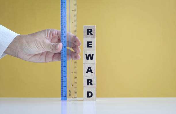 istock Woman's hand using ruler to measure reward. 1326732335
