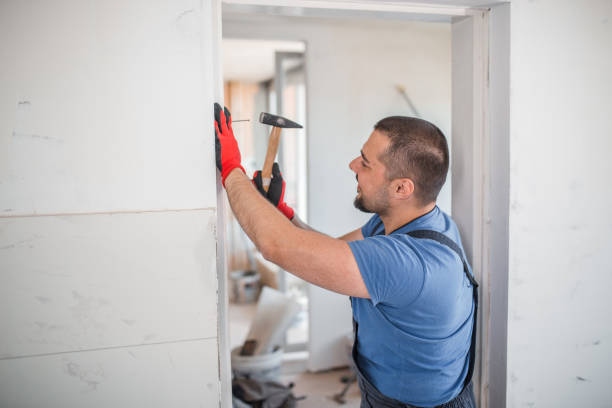 istock Smiling worker with protective gloves nailing a nail 1326732796