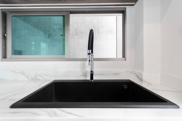 istock Luxurious black sink on a marble kitchen countertop. 1326734461