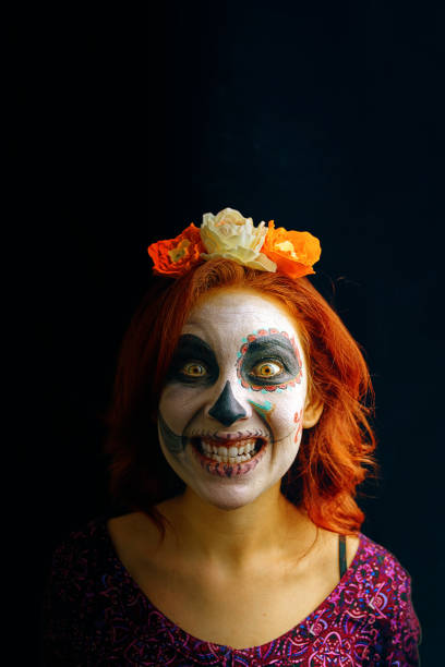 死んだマスクの頭蓋骨の日に若い女性は芸術に直面しています。 - witch smiling evil bizarre ストックフォトと画像