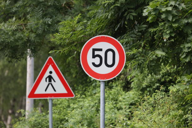 okrągły znak ograniczenia prędkości na drodze. 50 km na godzinę - kilometers per hour zdjęcia i obrazy z banku zdjęć