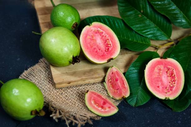 guava-frucht auf schwarzem hintergrund - guave stock-fotos und bilder