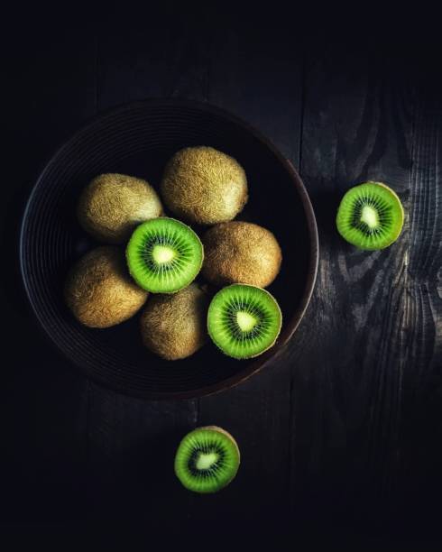 kiwi fruta em fundo preto - kiwi - fotografias e filmes do acervo