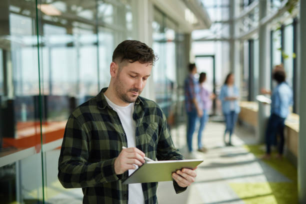istock A successful male web designer using digital tablet in the office hallway 1326744619