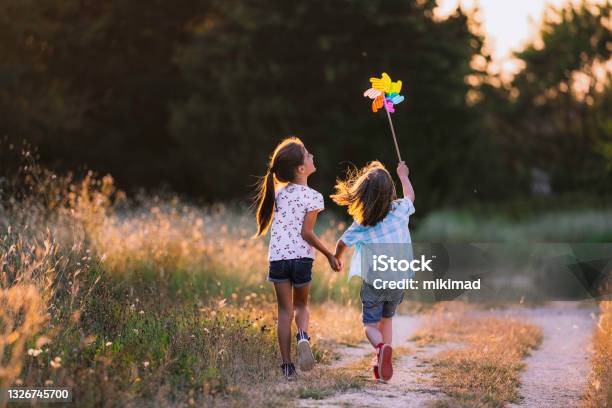Happy Kids Having Fun With Pinwheel In The Nature Running Kids Stock Photo - Download Image Now