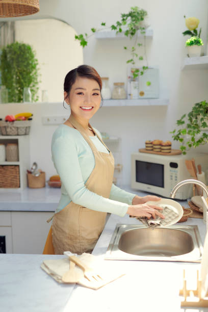 istock Asian lady wash a dish in kitchen room 1326747814