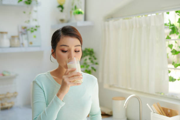 istock Happy young girl drink a milk for breakfast in kitchen conner. 1326747822