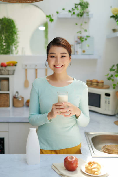 istock Smiling attractive woman having breakfast in kitchen interior 1326748368