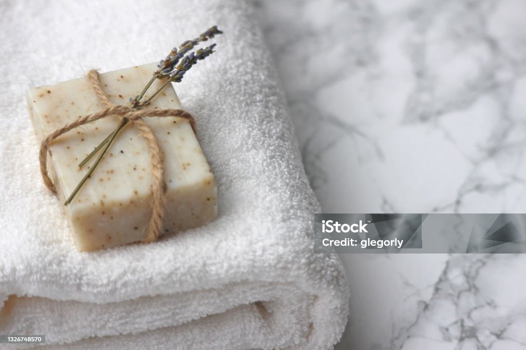 Handmade Organic Soap A bar of organic homemade soap on a fresh white towel. Hotel/B&B bathroom theme. Soap Stock Photo