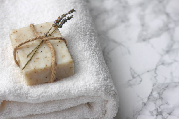 Handmade Organic Soap A bar of organic homemade soap on a fresh white towel. Hotel/B&B bathroom theme. towel photos stock pictures, royalty-free photos & images