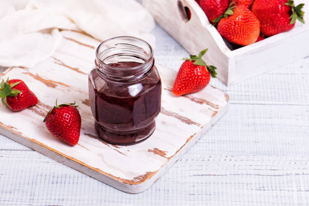 istock Jar of strawberry jam on wooden rustic board. 1326753966