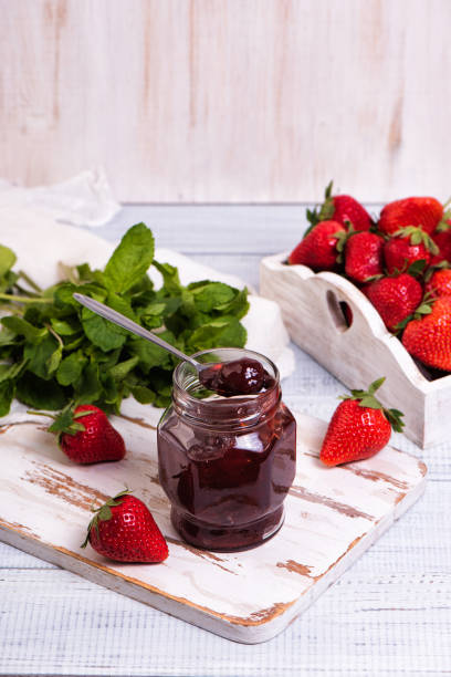 istock Jar of strawberry jam on wooden rustic board. 1326753978