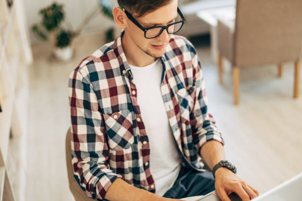 istock male worker uses computer in cafeteria, young man works using laptop 1326754859
