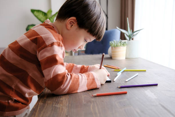 istock Cute child drawing at home 1326755312