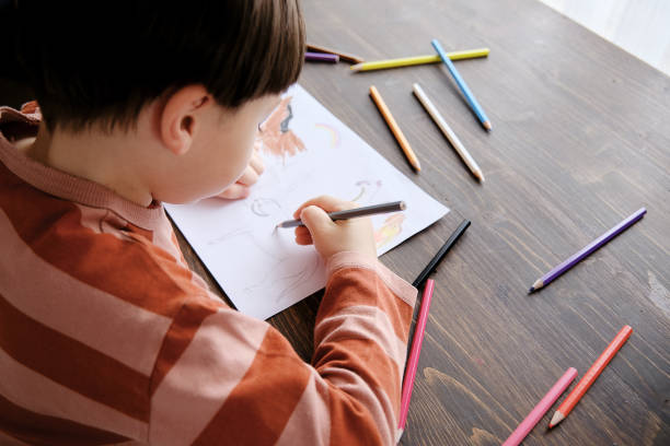 istock Cute child drawing at home 1326755325