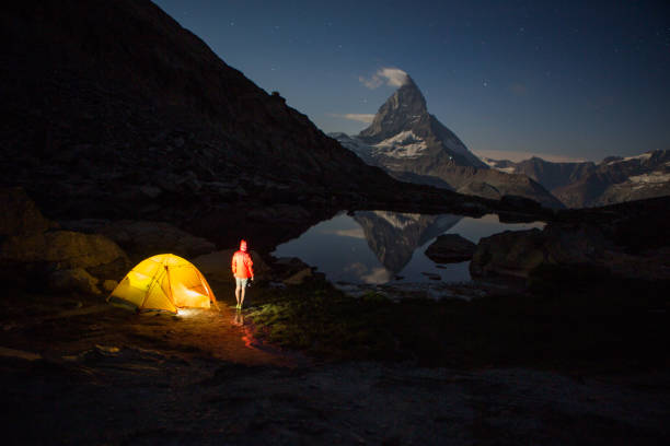 istock Man camping on mountain top, he is looking at stars 1326757808
