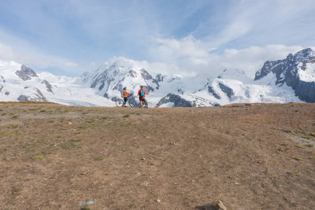 couple mountain bikers contemplate beautiful glacier in switzerland - european alps switzerland glacier high angle view imagens e fotografias de stock