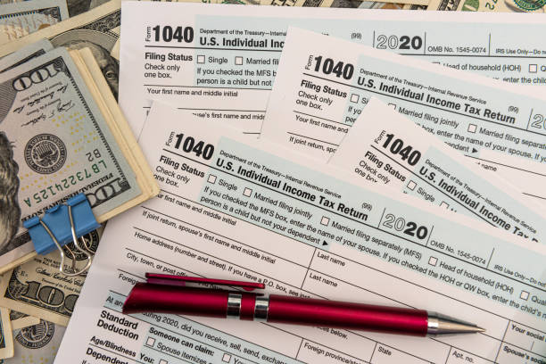 istock Tax Form 1040  with us 100 dollar banknotes 1326760377