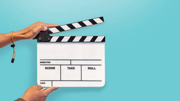 Hands with a movie clapperboard on blue background Man holding a movie clapperboard, studio shot soundtrack stock pictures, royalty-free photos & images