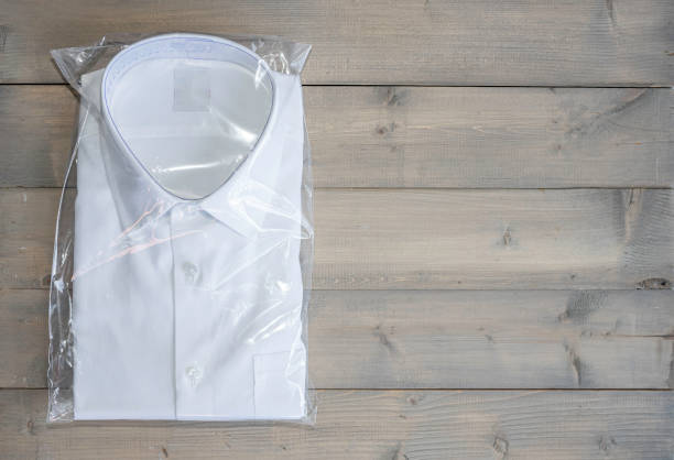 istock White shirt folding in the package on wooden background with copy space. 1326767931