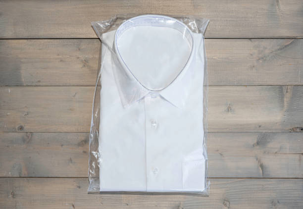 istock White shirt folding in the package on wooden background with copy space. 1326767942