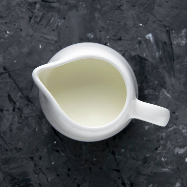 istock Milk jug on a black background, top view. 1326768906