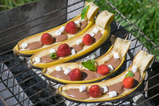 приготовление сладких бананов на углях. - grilled bananas стоковые фото и изображения