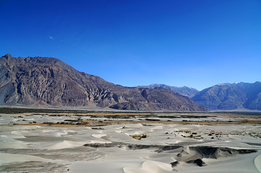 Paisaje Naturaleza Escena de textura de onda de duna de arena blanca con fondo de montaña gris marrón en Hunder Duna de arena Nubra Valley, Leh Ladakh, jammu y cachemira - India -viaje por la naturaleza fondo abstracto photo