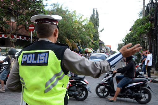 Bali, Indonesia- 15 Oct, 2019: Road policeman controls the traffic of vehicles in Bali, Indonesia.