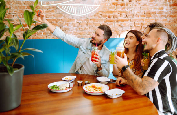 istock Selfie time! Young friends take a selfie and smile while relaxing in a cafe. 1326777690