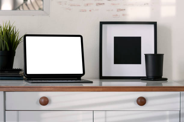 istock Black tablet with blank screen on wooden table and brick wall. 1326779784