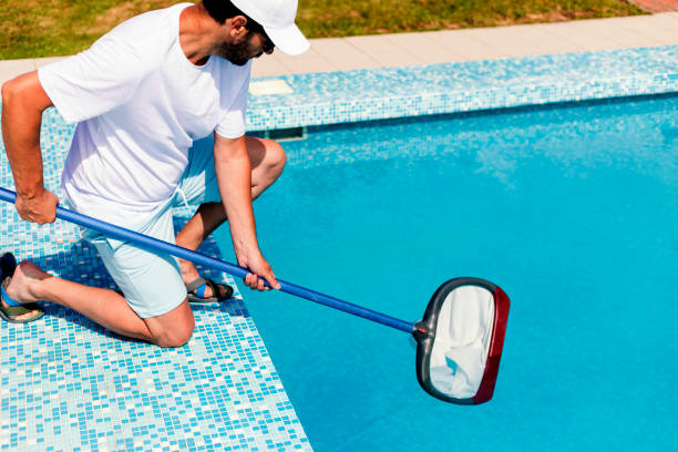 istock Man cleaning the swimming pool 1326781412