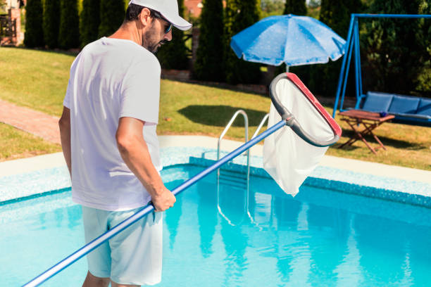 istock Man cleaning the swimming pool 1326781417