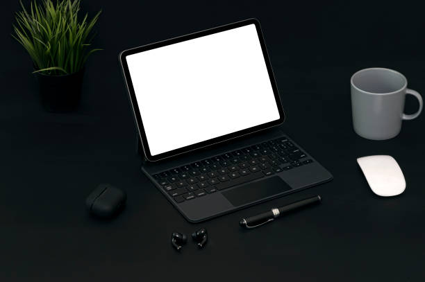 istock Dark tone color creative workspace. Blank screen tablet and gadget on black table. 1326782319