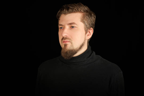 istock Cute bearded man, half-profile portrait, black background 1326783337