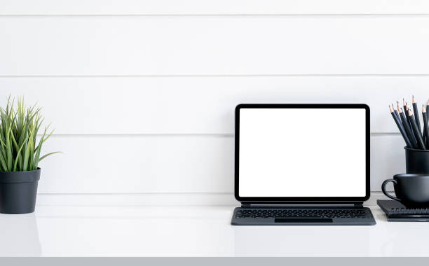 istock Mockup blank screen tablet with magic keyboard and supplies on white table. 1326783517