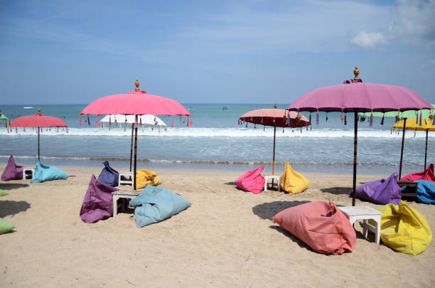 Empty beach background with bright tent, chairs, surf waves and sunny sky
