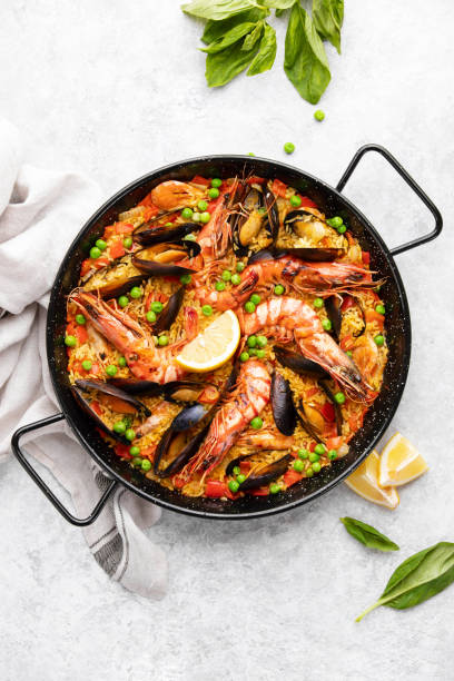 Seafood paella ready to eat served in a paella pan, top-down view stock photo