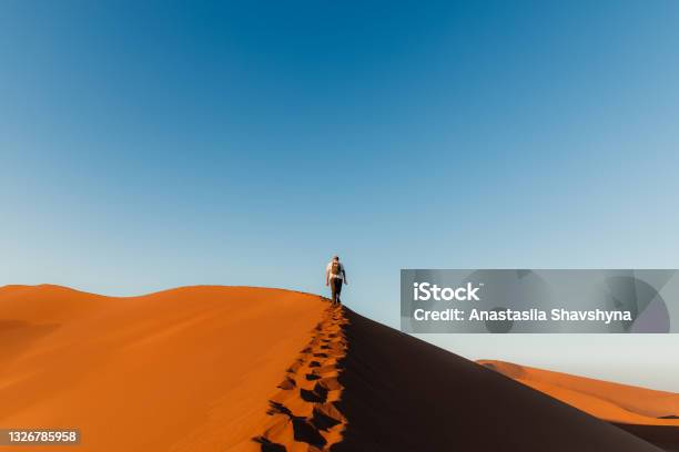 Man Traveler Enjoying The Scenic Sunrise From Top Of The Dune At Sossuvlei Namibia Stock Photo - Download Image Now