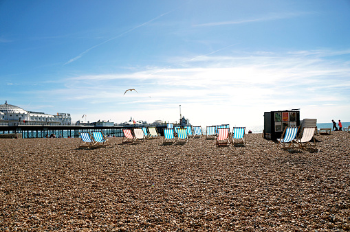 Pebble beach in Brighton with colourful sun loungers
