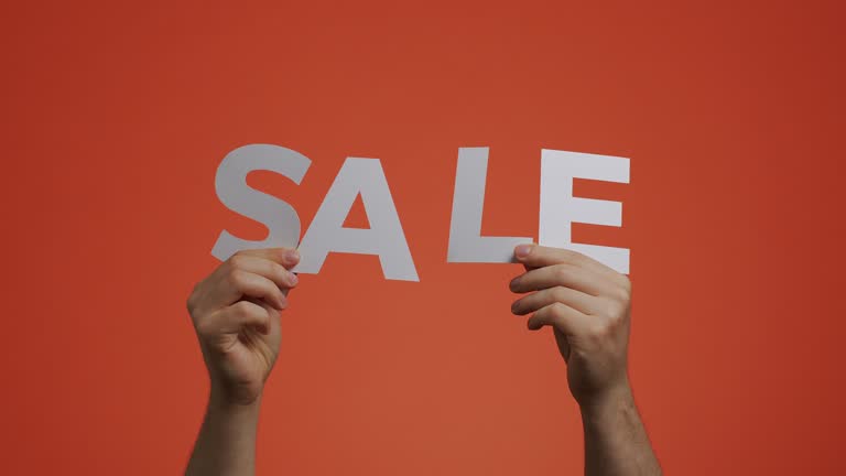 Sale announcement. Man showing sale sign on orange chromakey. Store discounts offer. Cheap shopping concept