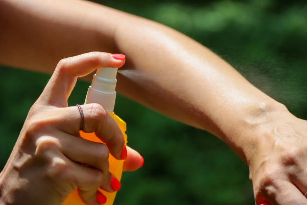 Person spraying mosquito insect repellent in the forest, insect protection Insect repellent against mosquitoes, ticks. Skin protection against tick and other insect. Bug spray anti insects. Woman spraying insect repellent using yellow spray bottle. mosquito stock pictures, royalty-free photos & images