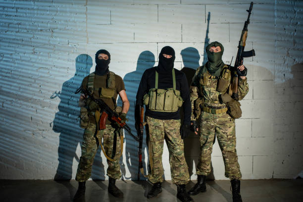 Group of unrecognizable officers with weapons Group of unrecognizable officers in military outfit holding weapons terrorist stock pictures, royalty-free photos & images