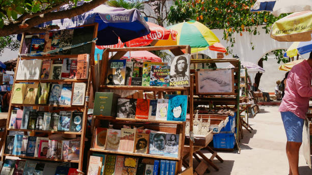 Street flea market with old books and parasols in the old town of Havana, Cuba Havana, Cuba - May 07, 2017: various books at the flea market in the old town of Havana cuba market stock pictures, royalty-free photos & images