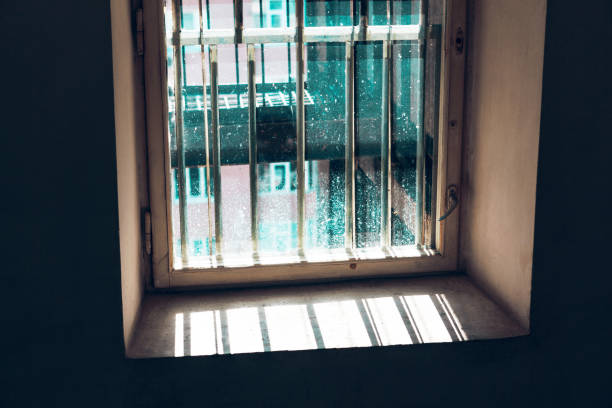 Dirty window with grates Dirty window with grates . Sunlight in the dark room . Light in the prison dungeon medieval prison prison cell stock pictures, royalty-free photos & images