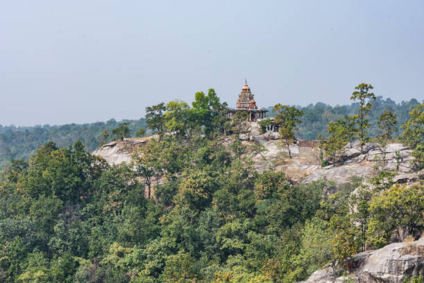 Lord shiva temple at top of a mountain which is situated at under greenery forest in odisha, india looking awesome from mountain peak. stock photo
