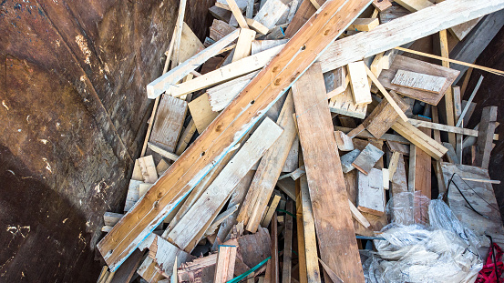 Construction site waste. Industrial dumpster full of scrap wood. Wastage in construction.