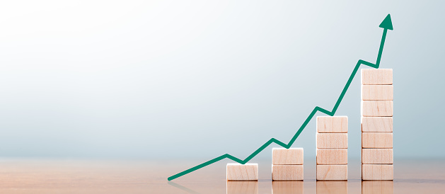 Wooden Block Statistics Graph With Arrow Showing Exponential Growth Trend